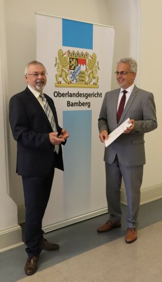 Der Präsident des Oberlandesgerichts Bamberg Lothar Schmitt und der Präsident des Landgerichts Bayreuth Matthias Burghardt bei der Urkundenübergabe (von links)