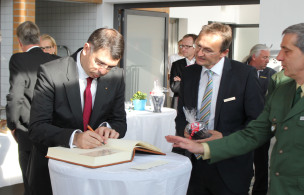 Der rumänische Justizminister Robert-Marius Cazanciuc (1. v.l.) trägt sich auf Einladung von Anstaltsleiter Andreas Stoiber (2. v.l.) in das Gästebuch der JVA Landshut ein