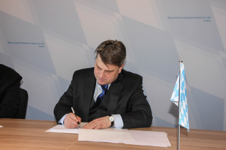Bayerns Justizminister Bausback bei der Unterzeichnung der gemeinsamen Erklärung